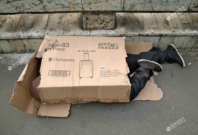 26/40罗马尼亚火车站外,一个流浪汉睡在破纸盒里.