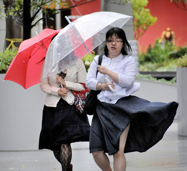23/25东京,两个女人在强风中行走,大风吹起一位女士的裙子.