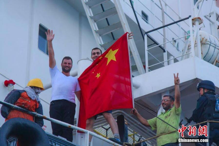 商船「OS35」船员兴奋地披上五星红旗。