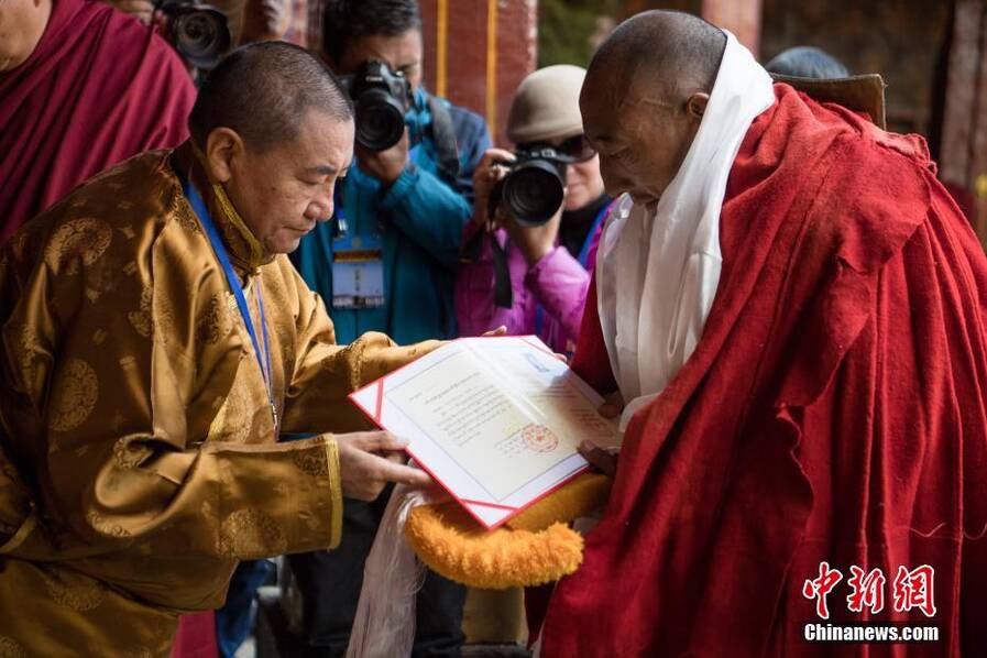 西藏佛学院院长珠康·土登克珠活佛(左)向考僧颁发格西拉让巴学位证书