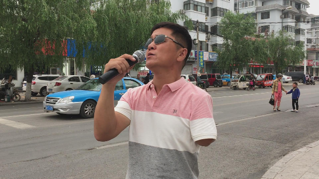 吉林一名农村残疾歌手在山东一城市街头激情高歌很好听哦