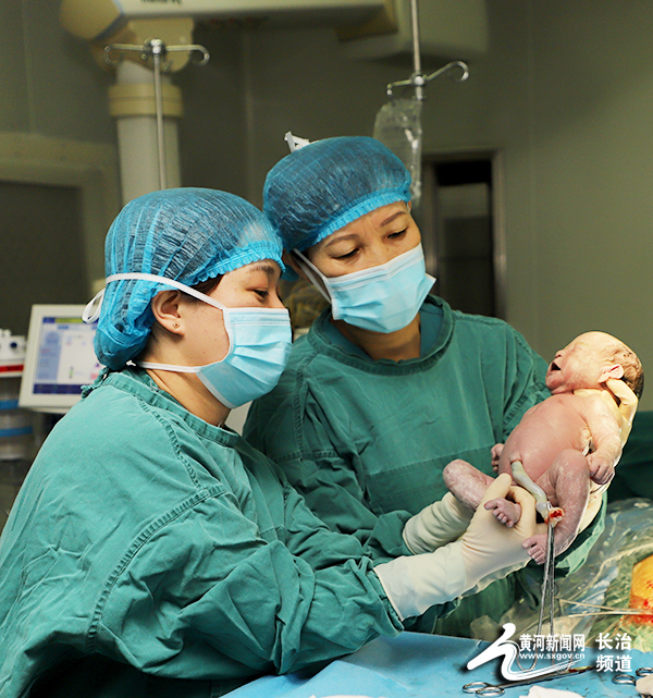 图为:医生抱着新出生的婴儿