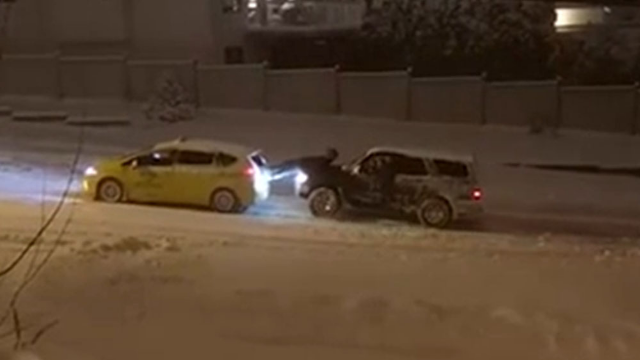出租车深陷雪地 男子用身体充当两车“连接器”推车
