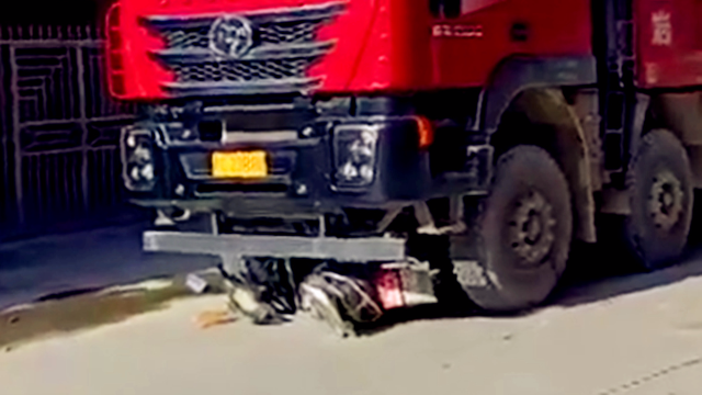 电动车与泥头车发生碰撞 现场狼藉电动车被卡车轮下