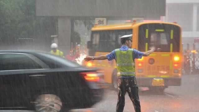 道外交警大队朱志滨洪水中指挥交通，帮助群众推车！