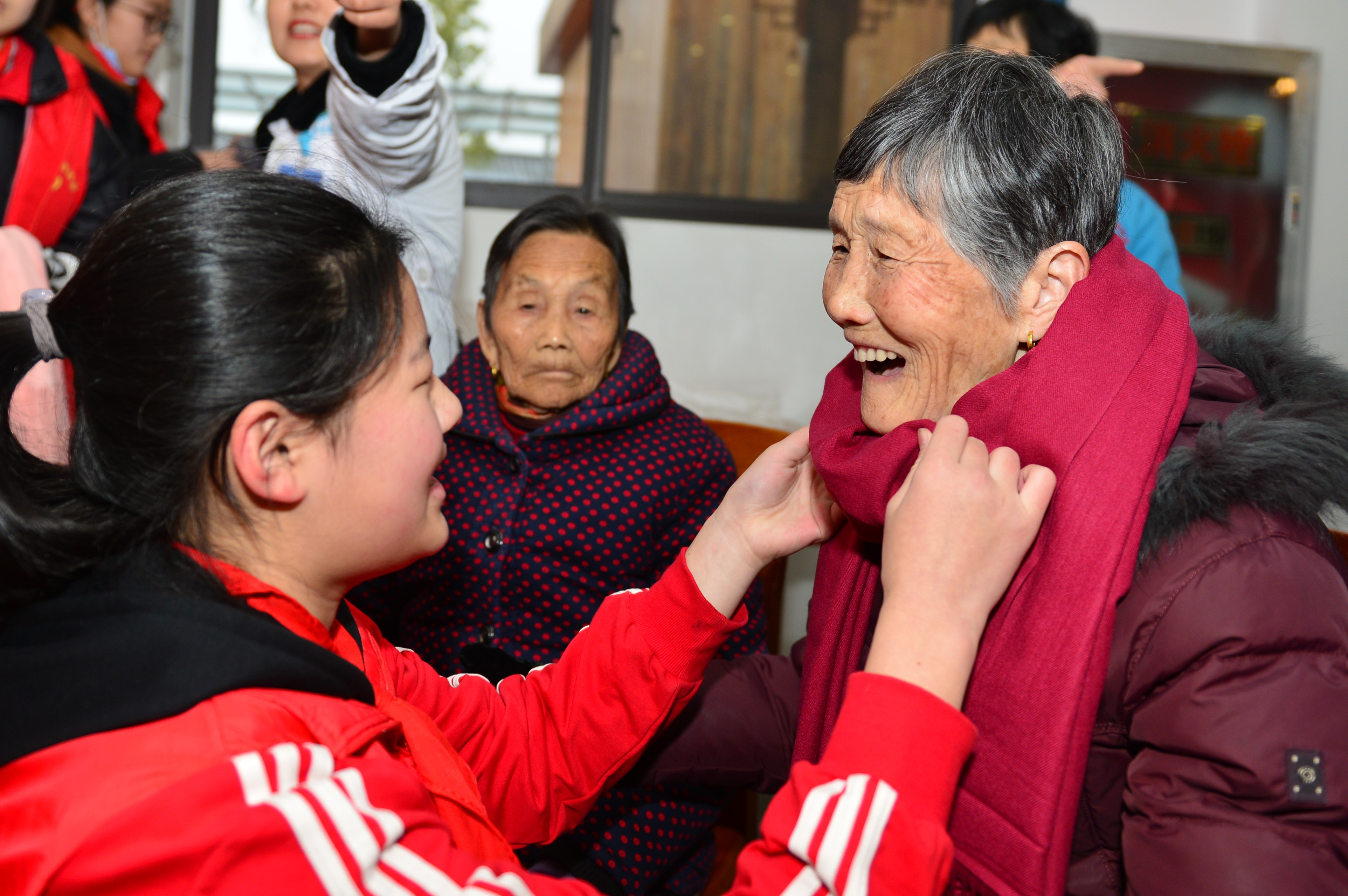 1月21日下午,在安徽省合肥市四季青敬老院,学生给老人戴爱心围巾.