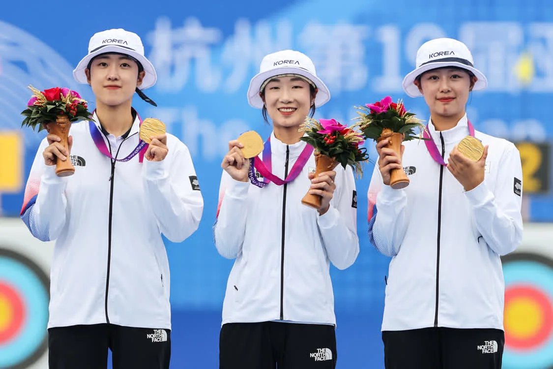 10月6日，冠军韩国队选手林是见（右）、崔美善（中）、安山在颁奖仪式上