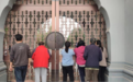 河南大学出入管控加强，市民从门缝遥望大礼堂