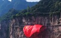 河南老君山、宝泉、云台山等多个景区挂出巨幅五星红旗,工作人员抱着国旗在山崖间共同展开,大批网友纷纷合影打卡