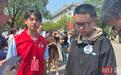 “八个鸡蛋”少年贺永辉到湖南农大报到,志愿者为其佩戴校徽,父亲贺秀堂请大家吃自家种的花生
