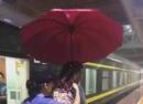 乘务员雨中为下车旅客撑伞 自己浑身湿透(图)