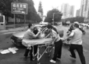 男子雨天遇车祸受伤倒地 交警举纸板为其遮雨(图)