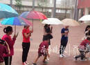 倾盆大雨中，十余老师排队为学生撑伞挡雨
