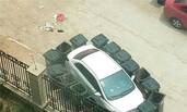 私家车“抢地盘” 被16个垃圾桶包围