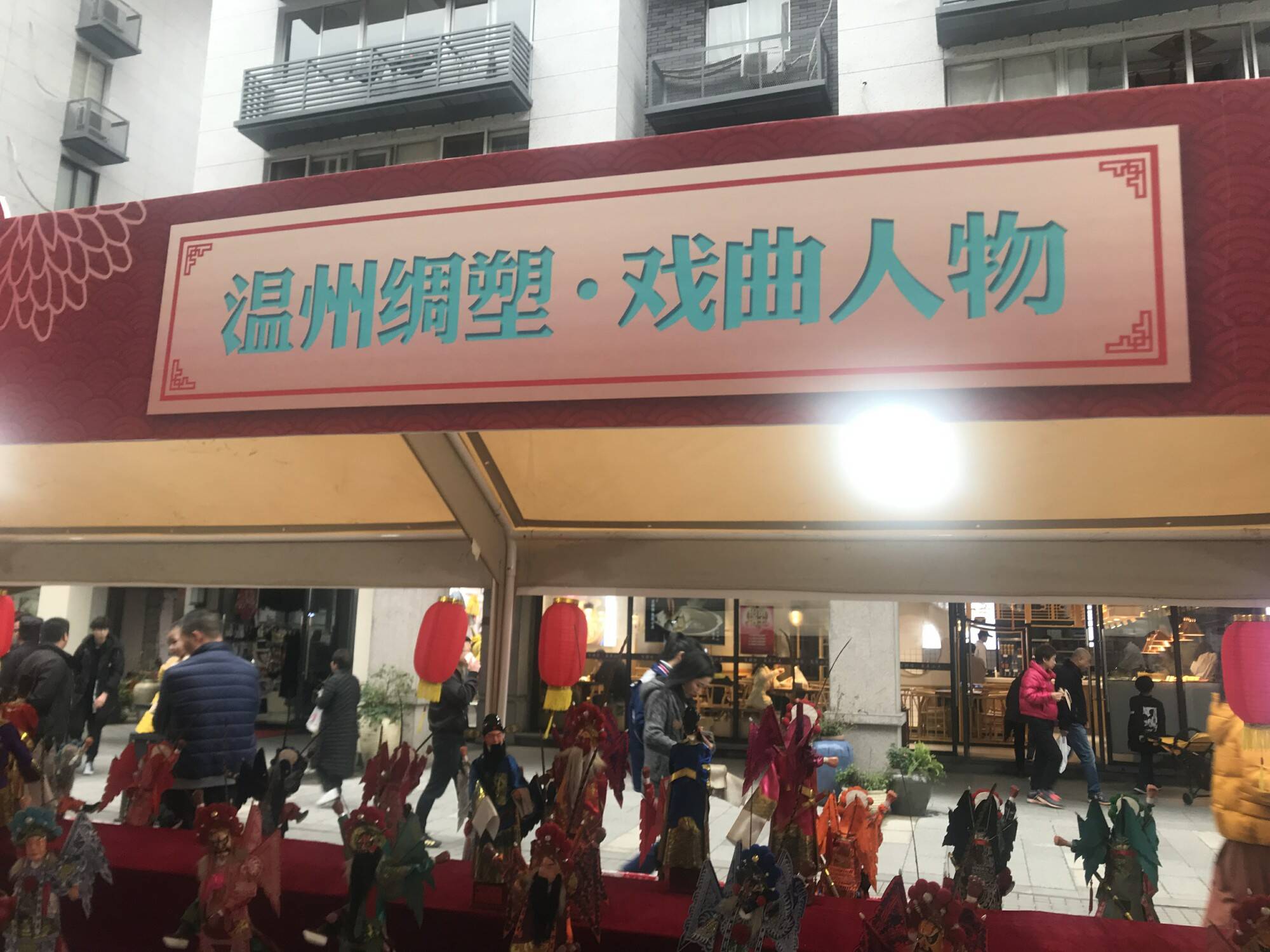 在一个临时搭建的棚子里,展示了温州的一种传统民间工艺品——绸塑.