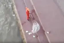 环卫工将垃圾扫进黄河