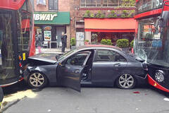 一台被夹在两辆公交之间的豪车