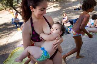 当地一个母乳喂养协会的成员在海边集体喂宝宝,呼吁妈妈们用自己的