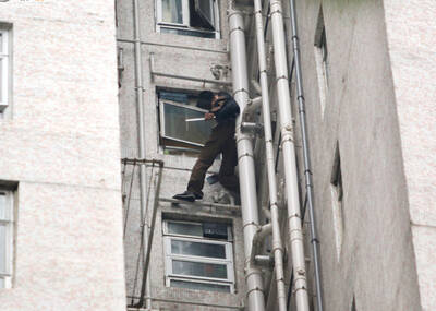 男子持双刀站18楼窗外