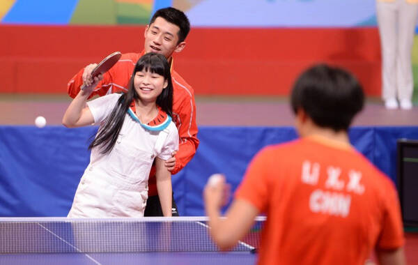 在奥运精英香港表演赛上，乒羽选手们和香港市民互动。本来是李晓霞和一个香港小女孩打球，张继科突然冒出来，搂着小女孩，手把手的教她打。