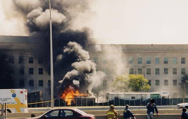 3月30日，美国FBI首次公布了这组2001年9月11日基地恐怖分子袭击五角大楼后数小时内拍摄的照片。图为消防队员和联邦调查局特工躲在路障后面，五角大楼上的火焰正在燃烧，他们不知道是否还会发生另一次袭击。