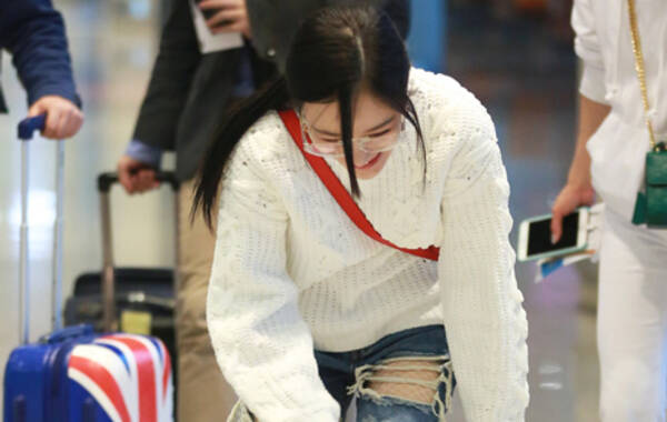 3月28日，李小璐现身首都机场。李小璐破洞裤+平底鞋性感又随性，走平路摔跤起来后忙捂脸羞涩笑。（图/视觉中国）