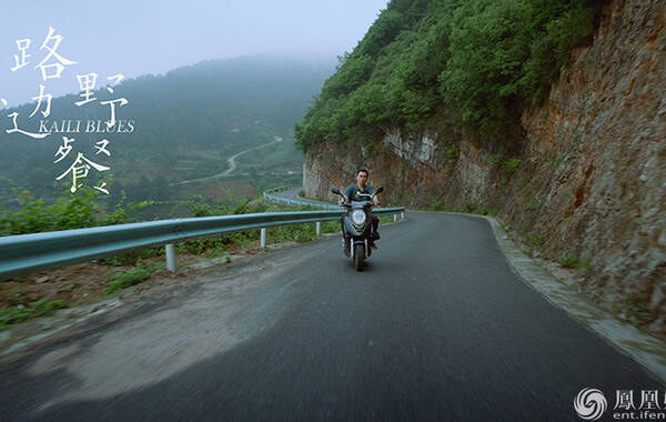 青年卫卫骑摩托车载着陈升飞驰在迷雾袅绕的盘山公路上。