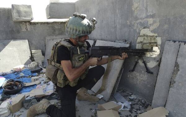 2014年6月19日，伊拉克精锐特种部队拉马迪市与极端武装进行作战。目前，在伊拉克政府军队中，仍保持战斗力的部队数量不多，其特种部队是主要力量。该部队在美军驻扎时期，经常与美军配合作战。实战经验多，战斗力比较强。图为一名特种部队成员使用机枪进行盲射。