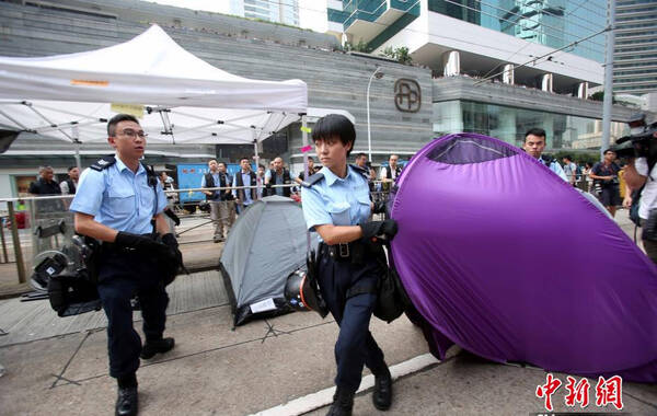 10月14日，香港警方采取果断措施，清除金钟道障碍物。图为警员移除道路上的帐篷。中新社发 洪少葵 摄