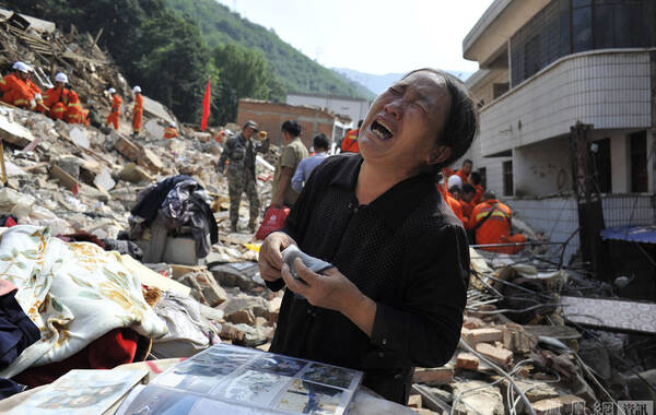8月3日16时30分在云南省昭通市鲁甸县发生了6.5级地震。截至8月6日10时30分初步统计，云南昭通鲁甸地震已造成589人死亡，9人失踪。图为8月6日，一位中年妇女在自己家的废墟前痛哭，她上大学的儿女和一个儿媳妇在地震中遇难。