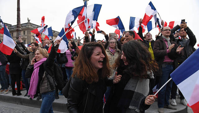 卢浮宫门前举旗狂欢的法国民众