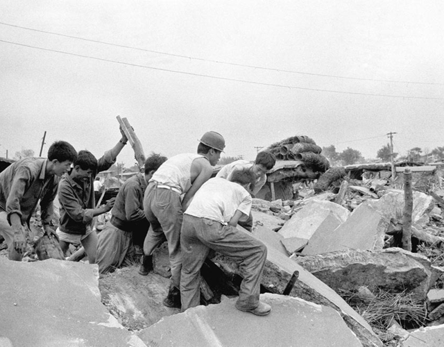 1976年7月,唐山大地震后,人们在清理废墟 视觉中国