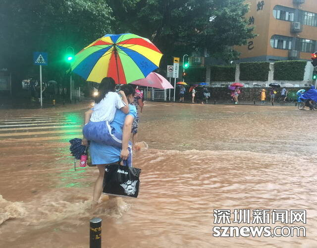 6月13日,深圳景龙小学附近,因水太深,家长怕孩子单独走路危险,背起