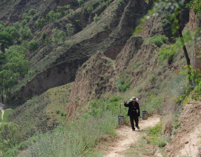 山路非常陡,是村里人在山坡上用铁锨铲开的一条土路.