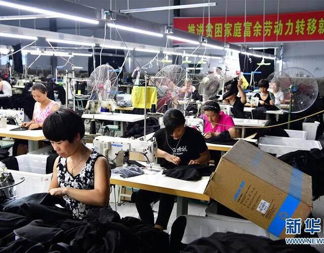 7月25日,在河南省周口市沈丘县纸店镇潘董庄精准扶贫就业点,村民在一个制衣车间里工作。河南省周口市沈丘县采取“扶贫车间”进村措施,将企业的车间延伸到农村,利用农村废弃的校舍、闲置的民宅和活动场地设置就业扶贫点。目前,沈丘已建成74个扶贫就业车间,涉及电子、环保手袋、纺织服装加工等,带动5000余人就近就地就业。新华社记者 冯大鹏 摄 7月25日,在河南省周口市沈丘县纸店镇潘董庄精准扶贫就业点,村民在一个制衣车间里工作。河南省周口市沈丘县采取“扶贫车间”进村措施,将企业的车间延伸到农村,利用农村废弃的校舍、闲置的民宅和活动场地设置就业扶贫点。目前,沈丘已建成74个扶贫就业车间,涉及电子、环保手袋、纺织服装加工等,带动5000余人就近就地就业。新华社记者 冯大鹏 摄
