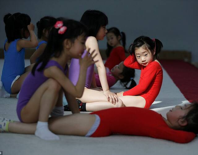 练习体操的小女孩正在压腿