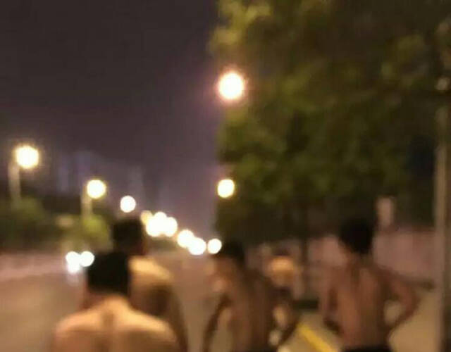 图为一群男生被罚在大街上裸奔。