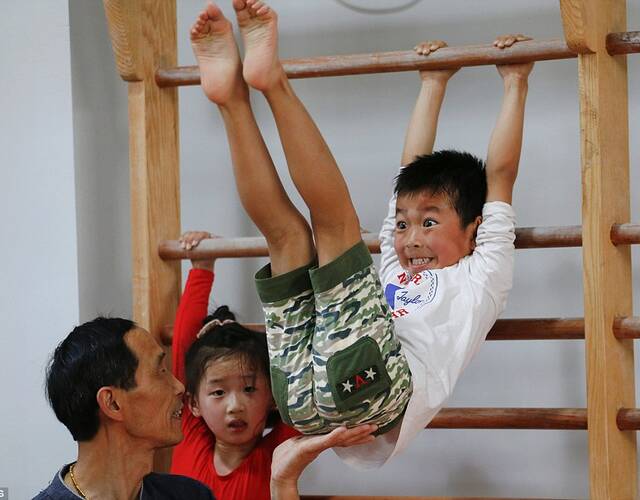 女孩在体操课上做手倒立,图为上海杨浦青少年业余体育学校.