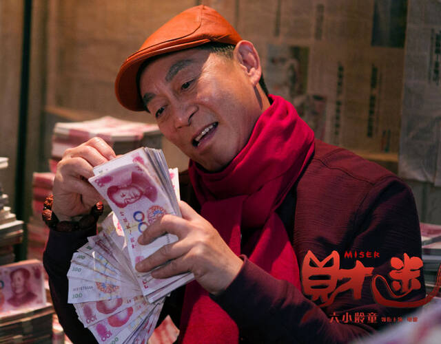 六小龄童坐在一堆钱中微笑