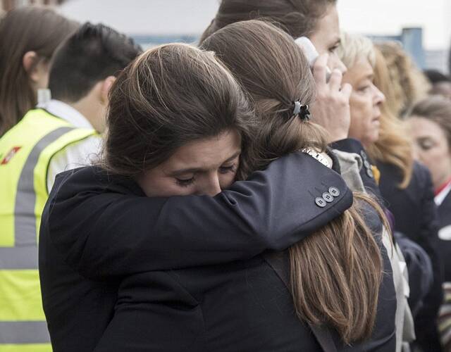 在乘客和工作人员撤离布鲁塞尔机场时,两名女子拥抱安慰.