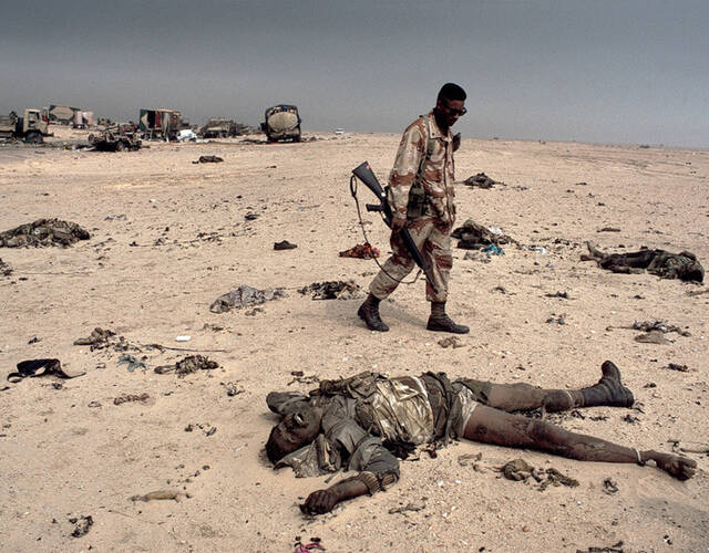 1991年海湾战争,美军士兵察看被烧焦的共和国卫队士兵的尸体.