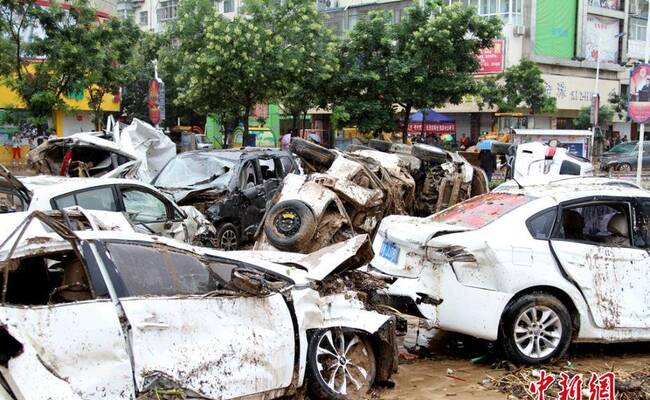 陕西水灾后清淤 受损汽车堆满街