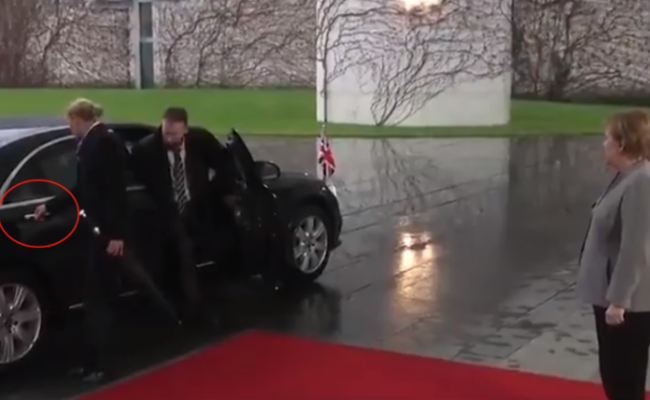 英国首相会见默克尔 下车时被锁车里
