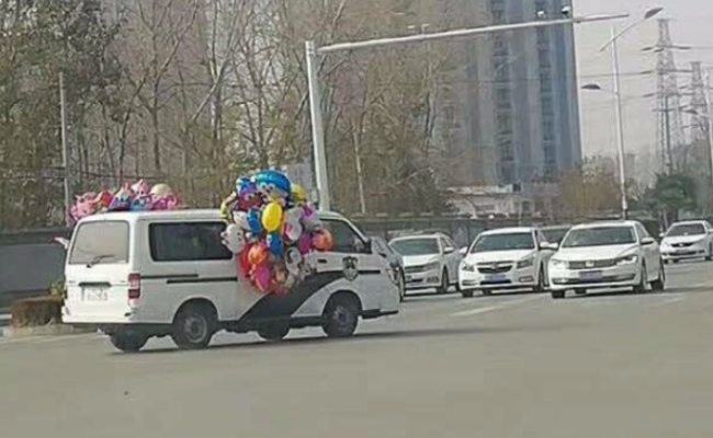 警车系满气球开上马路一幕