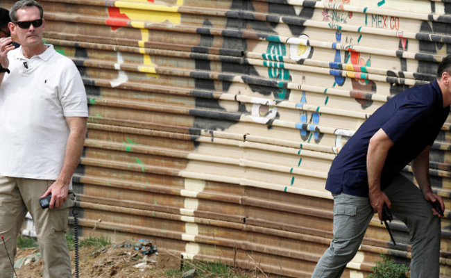 特朗普视察隔离墙，安保人员贴墙观察