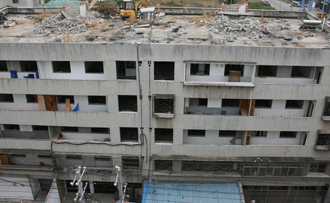 楼下住户未搬离 楼顶挖掘机开拆