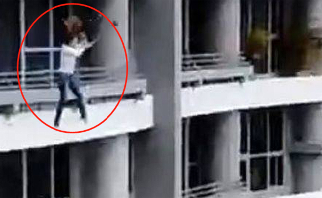 女子坐阳台栏杆上自拍 从27楼摔下身亡