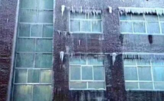 雾炮车“用力过猛” 环保局大楼被喷成冰雕