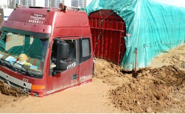 陕西：暴雨后货车被困淤泥中