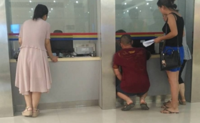 法院窗口前 民众蹲着办事